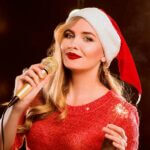 Female Party Band Leader With Santa Hat Performing Live Music For A Corporate Holiday Party